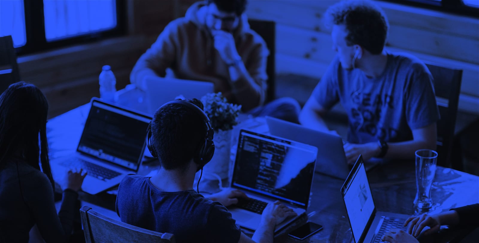 Men and women working on their laptops while appearing to solve a problem.