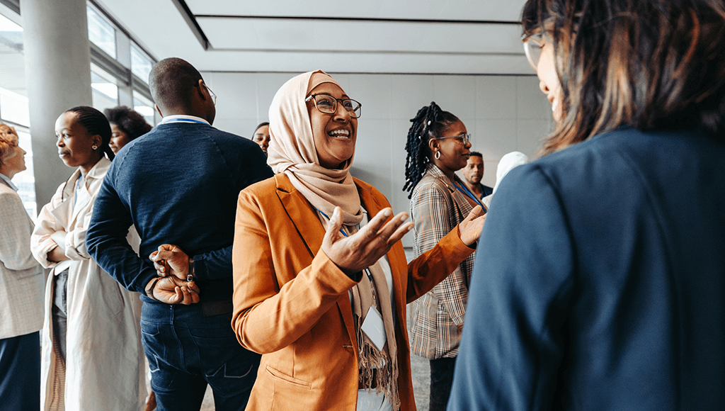 Woman wearing a hijab conversating at an event.
